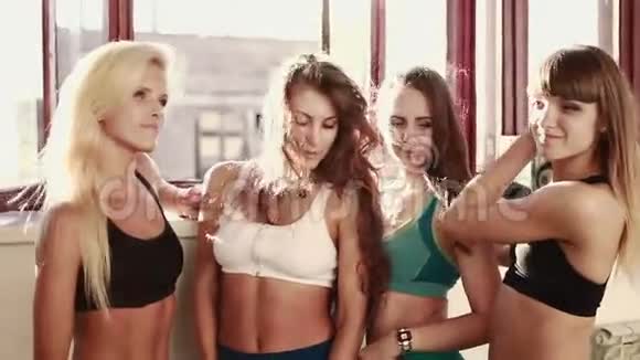 一组四个人穿着五颜六色的衣服在健身房做有氧运动或热身体操和伸展运动视频的预览图