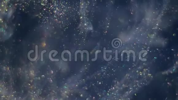 在黑暗的空间背景上充满微小的bokeh金闪闪发光的气泡的溪流是随机和混乱的视频的预览图