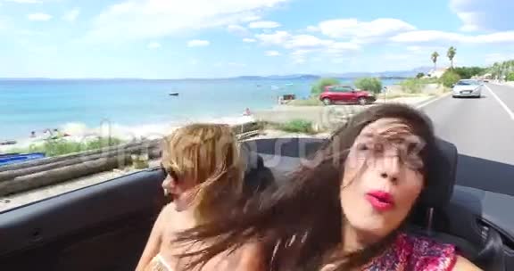 两个迷人的女孩开着敞篷车顶着头享受着风视频的预览图