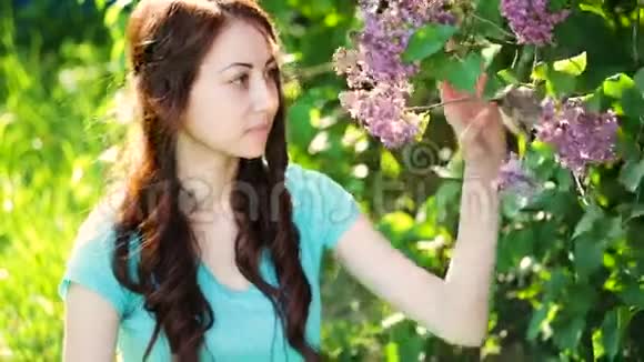 盛开的春天花园里的年轻美丽的女人视频的预览图