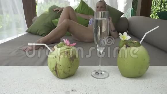 这位年轻苗条的女士在棕榈树下的热带度假胜地休息视频的预览图