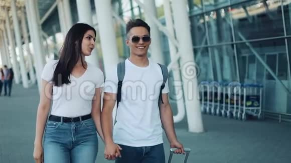 幸福的年轻夫妇带着行李去机场或火车站附近旅游度假度假的概念视频的预览图