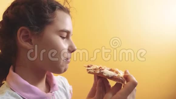 快乐的小女孩吃一片披萨的概念青少年儿童饥饿吃生活方式一片比萨饼慢动作视频的预览图