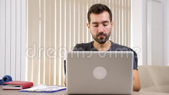 一个人在客厅里用笔记本电脑打字视频的预览图