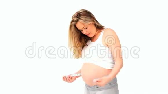 可爱的孕妇带着测量带视频的预览图