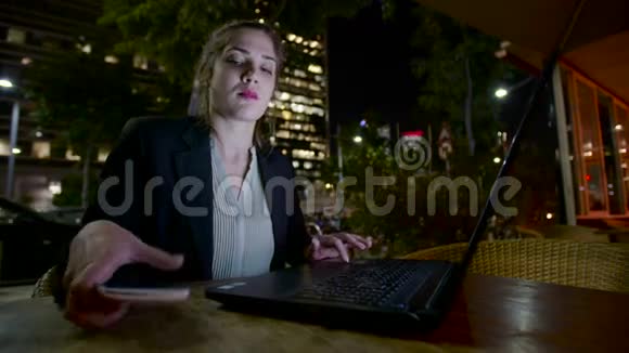 商务女性晚上坐在咖啡馆里在笔记本电脑上工作打电话视频的预览图