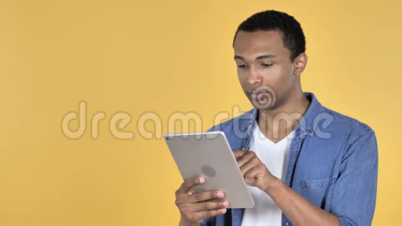 非洲青年男子浏览互联网使用平板电脑视频的预览图