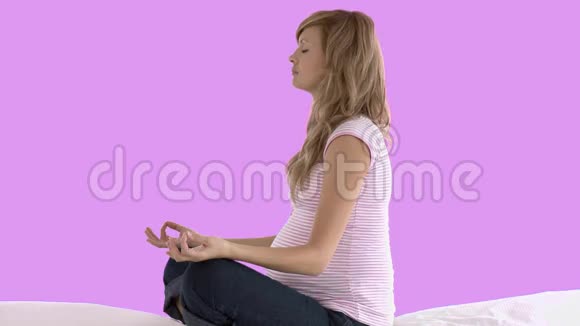 未来妈妈在粉色背景下做瑜伽视频的预览图