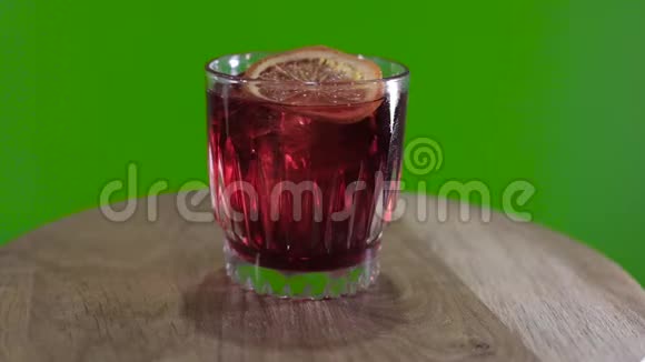 绿色背景上的威士忌酒杯hromokoy背景上的鸡尾酒旋转绿色背景上的酒精鸡尾酒视频的预览图