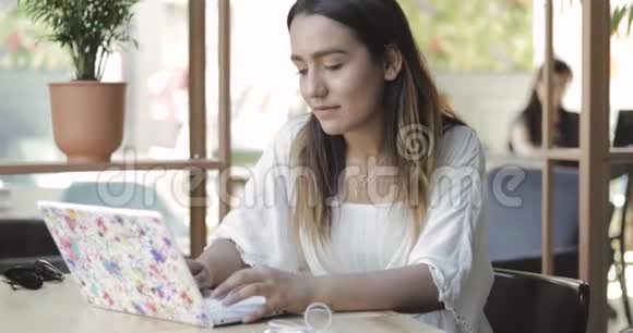 美丽的民族女孩坐在笔记本电脑视频的预览图