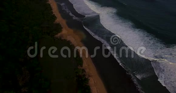空中无人驾驶飞机拍摄到日落时海浪在海岸前破碎的画面印度尼西亚巴厘视频的预览图