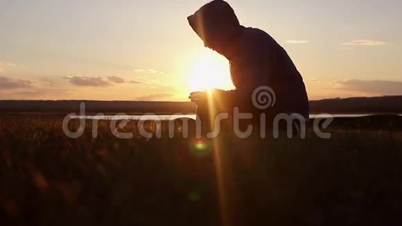 一个人在日落时分祈祷宗教观念的剪影视频的预览图