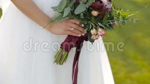 新娘手里捧着美丽的婚礼花束新娘手里拿着结婚花束视频的预览图
