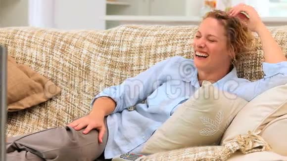卷发女子在电视机前笑视频的预览图