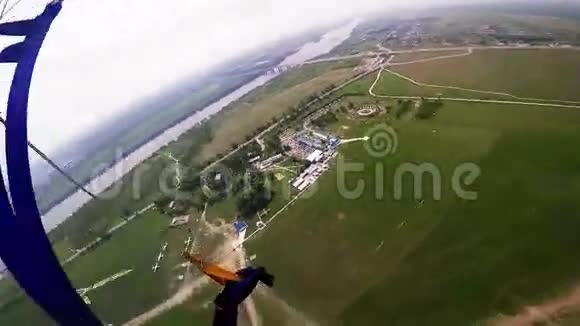 专业跳伞运动员飞行于绿色平地之上森林夏天景观视频的预览图