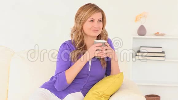 迷人的金发女人一边喝酒一边思考视频的预览图