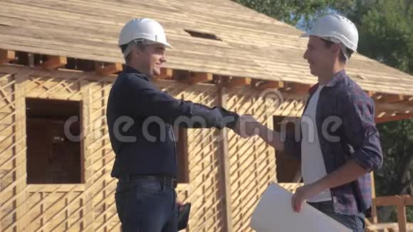 团队合作握手概念建筑构建建筑师慢动作视频两个戴头盔的人握手视频的预览图