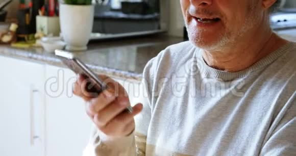 老人在家厨房里用手机说话视频的预览图