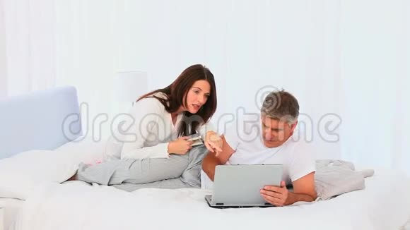 中年夫妇看着笔记本电脑视频的预览图