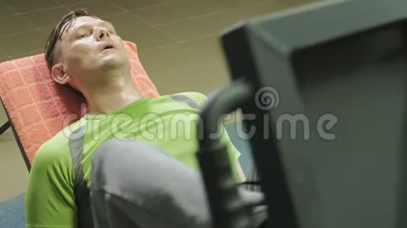 一个超重的男人在健身房里用模拟机做腿部按压健身训练健康生活方式理念视频的预览图