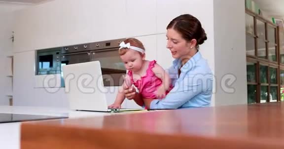 女商人带着她的孩子用笔记本电脑视频的预览图