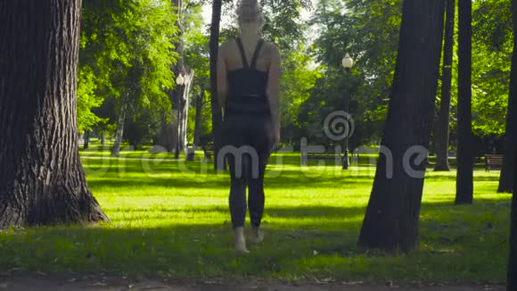一个年轻女子赤脚走在草地上视频的预览图