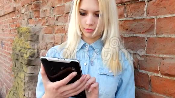 美丽的金发女郎使用平板电脑的形象视频的预览图