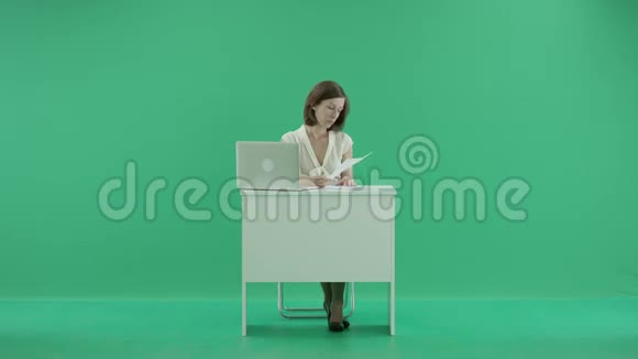 女人坐在桌子旁手提电脑和文件视频的预览图