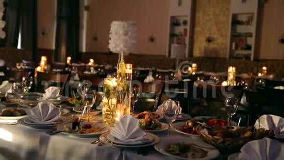婚宴大厅内部细节与装饰餐桌设置在餐厅蜡烛和白色花瓣装饰视频的预览图