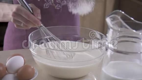 雌性的手在搅拌碗中搅拌面粉和鸡蛋视频的预览图