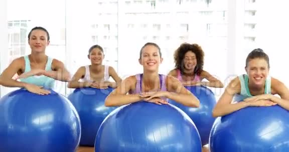 健身教室里的健身课靠在健身球上对着镜头微笑视频的预览图