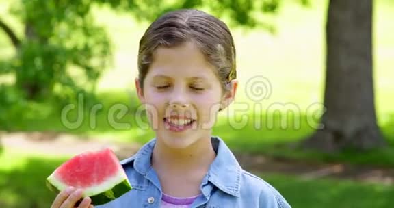 可爱的小女孩在公园里吃西瓜视频的预览图