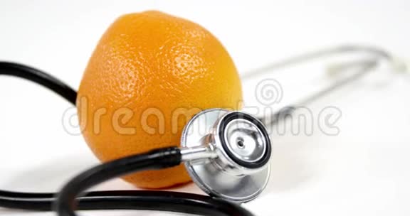 白色背景下的听诊器和橙色水果视频的预览图