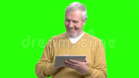 微笑老人使用数字平板电脑视频的预览图
