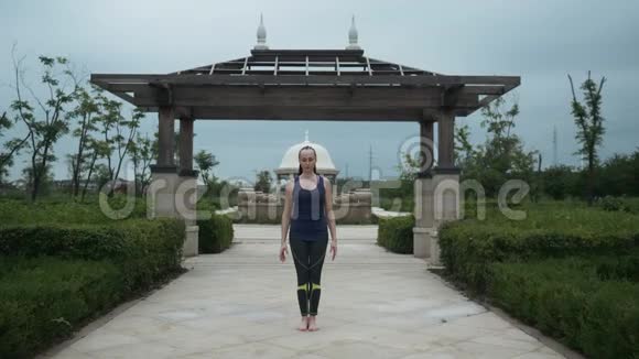 年轻的白种人穿着运动服光着脚在城市公园练习瑜伽放松日出背景慢慢视频的预览图
