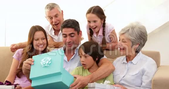 一家人看着父亲打开礼物视频的预览图