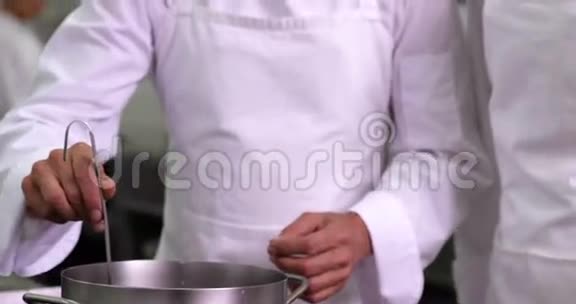 厨师向同事展示锅的内容然后对着镜头微笑视频的预览图