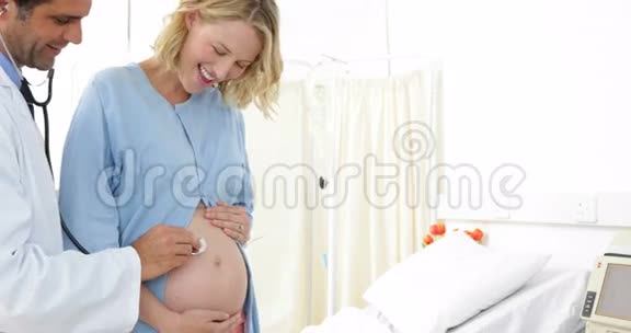 孕妇站在医院服上接受医生检查视频的预览图