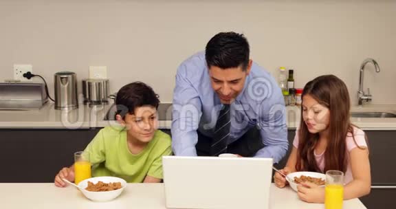 在父亲上班前用手提电脑和孩子微笑视频的预览图
