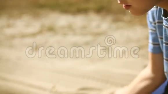 少年大手男孩洒沙象征时间沙漠视频的预览图