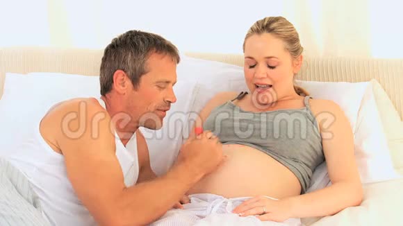 一个男人在怀孕的女人肚子上视频的预览图