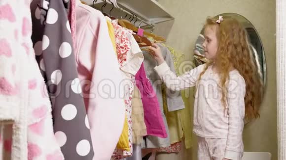 漂亮的小女孩在家庭衣柜里选择连衣裙美丽与时尚视频的预览图