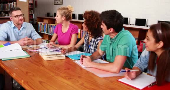 年轻学生和老师一起在图书馆学习视频的预览图