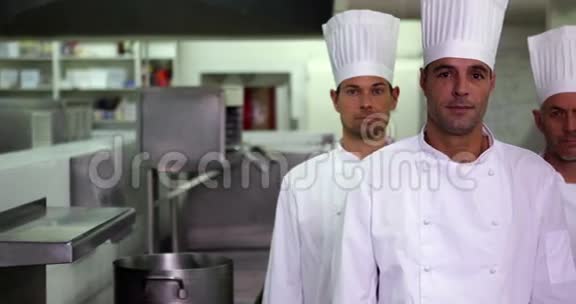 四位严肃的厨师交叉双臂看着摄像机视频的预览图