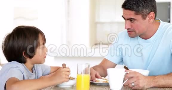 一个男人在早餐时和儿子聊天视频的预览图
