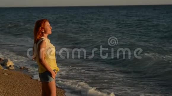 站在亚得里亚海多岩石的海滩上的一飞扬的年轻女子视频的预览图