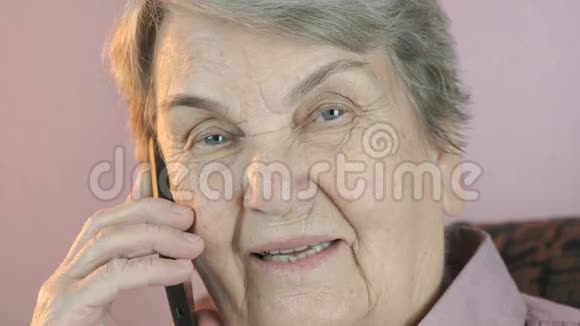80多岁的老年妇女在手机上微笑交谈视频的预览图