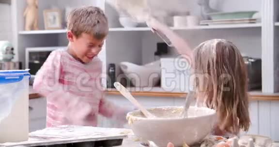 儿童在厨房中享受混乱乐趣的慢动作镜头视频的预览图