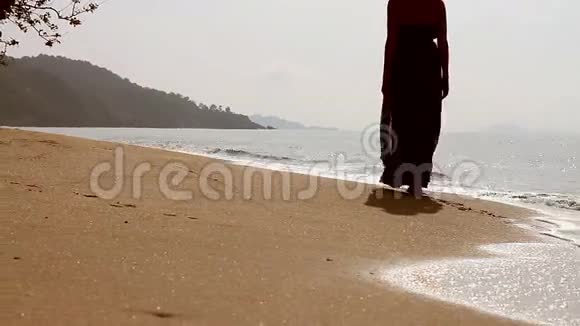 在海边沙滩上散步的女孩视频的预览图