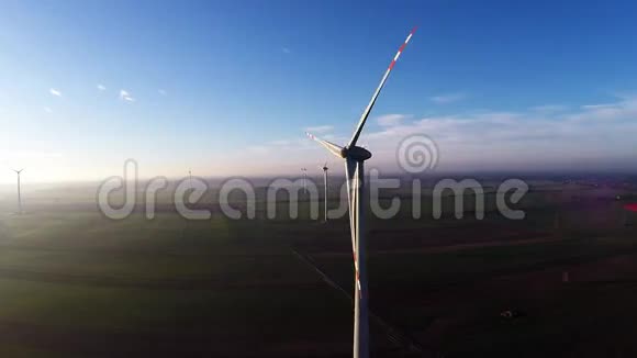 绿色乡村风力涡轮机在明亮的日落光线下的空中视野视频的预览图